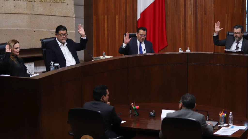 Tribunal-electoral-federal - Justicia Regia Five Officials in a Curved Wood-paneled Chamber Raise Their Hands During a Vote, with a Mexican Flag in the Background. - Justicia Regia