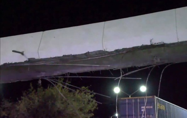 Image - Justicia Regia Nighttime: a Damaged Elevated Concrete Roadway with Exposed Rebar and Dangling Wires, a Container Truck Visible Below. - Justicia Regia