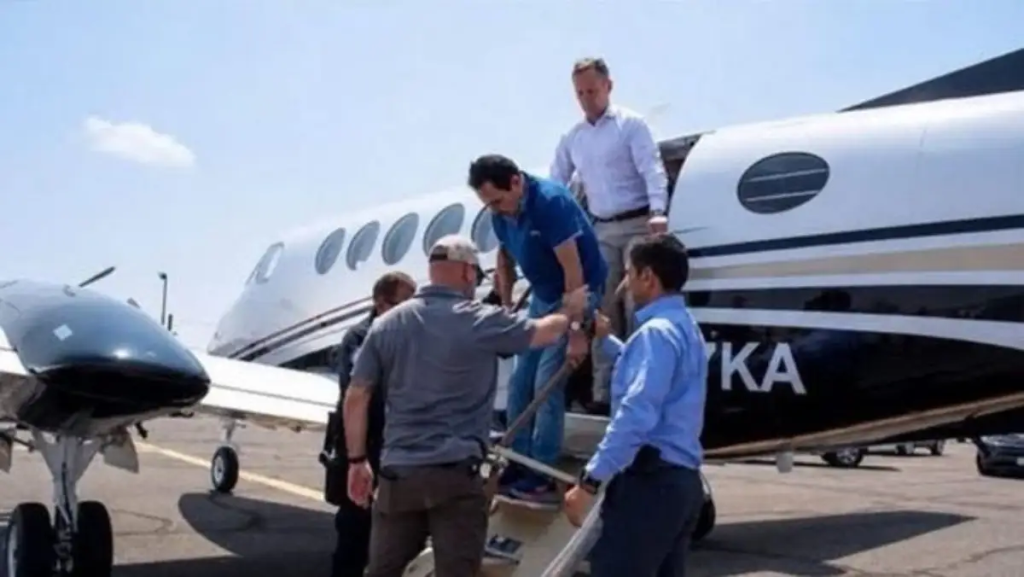 Group of Men Helping a Passenger Up Portable Stairs to a Private Jet on a Sunny Tarmac - Justicia Regia