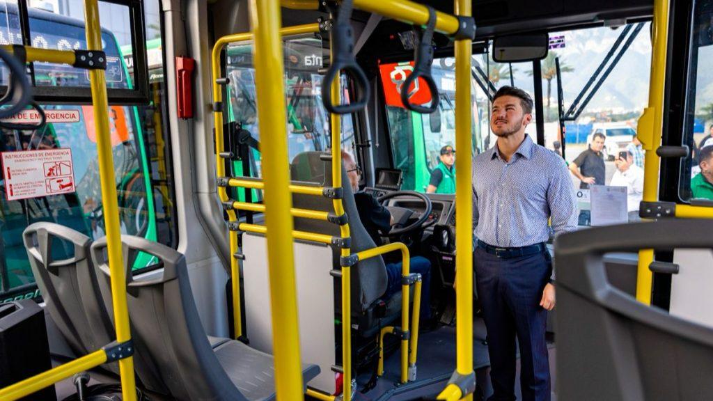 Camiones-nuevo-leon 1 - Justicia Regia Man in a Blue Checkered Shirt Stands Inside a Bus, Near the Driver’s Seat, Surrounded by Yellow Handrails. - Justicia Regia