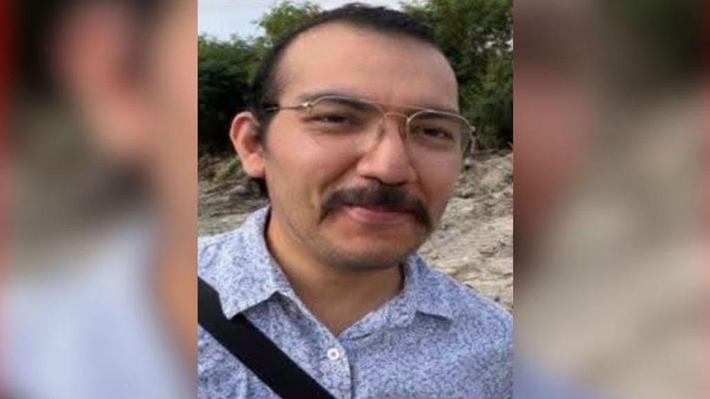 Portrait of a Man with Glasses and a Mustache Outdoors, Wearing a Light Patterned Shirt and a Strap Across His Chest. - Justicia Regia